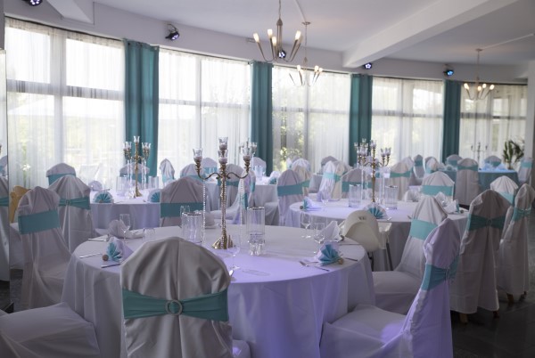 Weiße und blaue Dekoration der Tische und Stühle im Restaurant für eine Hochzeit