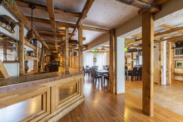 Gemütlicher Raum mit Bar und Tanzfläche und viel Holz, Stühle zum mieten.